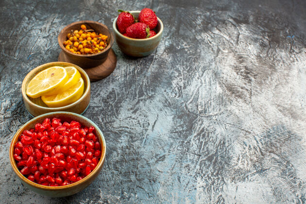 正面前视剥皮的石榴与其他水果放在深色浅色桌上 颜色鲜美食品营养配料