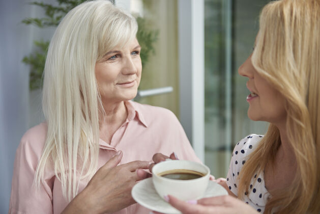 退休特写成年女性在阳台上享受美味的咖啡老年女性休闲服咖啡