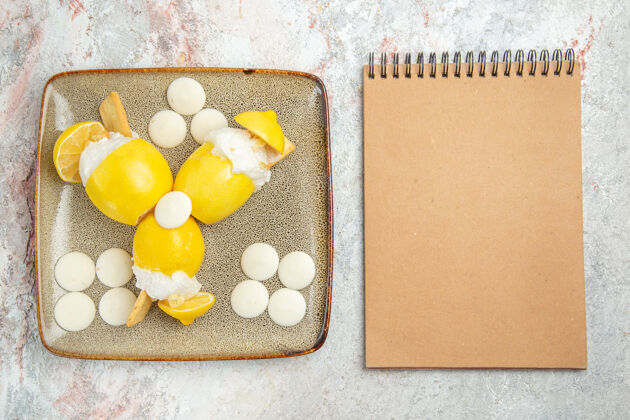 果汁在白色的桌子上俯瞰冰柠檬和白糖果健康有机纸板
