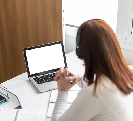 笔记本电脑工作中的女人正在笔记本电脑上进行视频通话工作办公桌设备