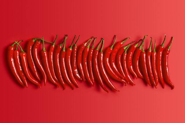 辛辣单独拍摄的红辣椒与绿色的茎和闪亮的皮肤辣椒调味墨西哥符号辛辣产品的收集选择性的重点健康的烹饪理念新鲜蔬菜草药辣平面
