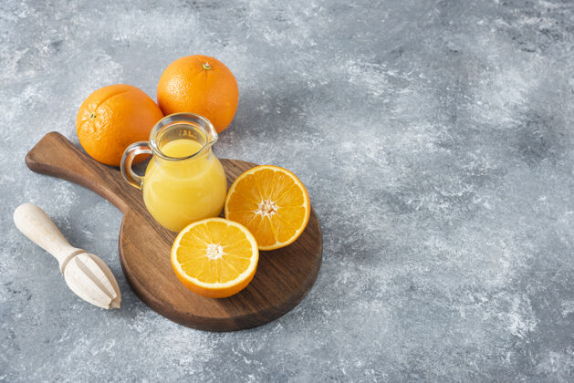 橙子石桌上放满了橙子汁的木板异国情调提神甜点