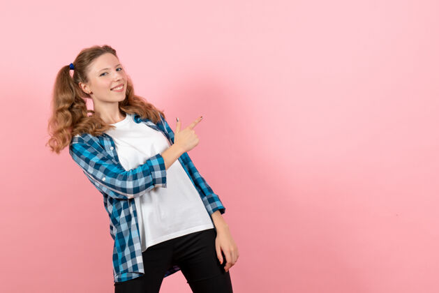 年轻正面图：穿着格子衬衫的年轻女性在粉色背景上摆姿势模特女性情感儿童青春色彩格子衬衫成人