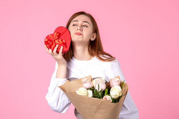 礼物正面图：年轻女性 带鲜花 作为妇女节礼物 粉色背景 水平三月平等日 玫瑰色 女人爱感性花束玫瑰年轻女性