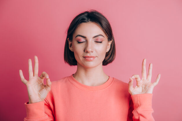瑜伽背景上穿着休闲毛衣的女人放松 闭着眼睛微笑 用手指做冥想姿势瑜伽概念放松复制空间和平