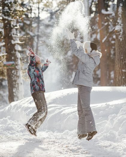 下雪全鏡頭女人和女孩一起玩旅行冬天孩子