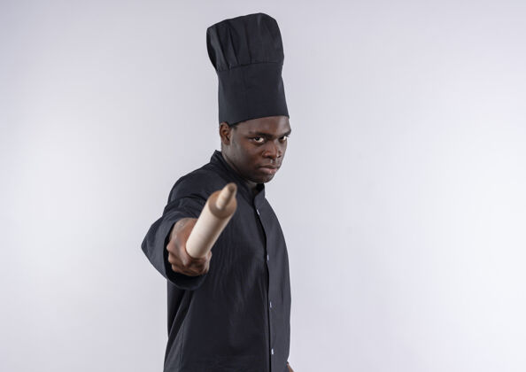 空间年轻自信的非洲裔美国厨师身着厨师制服 拿着擀面杖在白色地板上 留有复印空间制服厨师烹饪