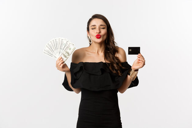 魅力美丽和购物的概念美丽迷人的女人撅起嘴唇亲吻 显示信用卡和美元 站在白色背景优雅女人模型