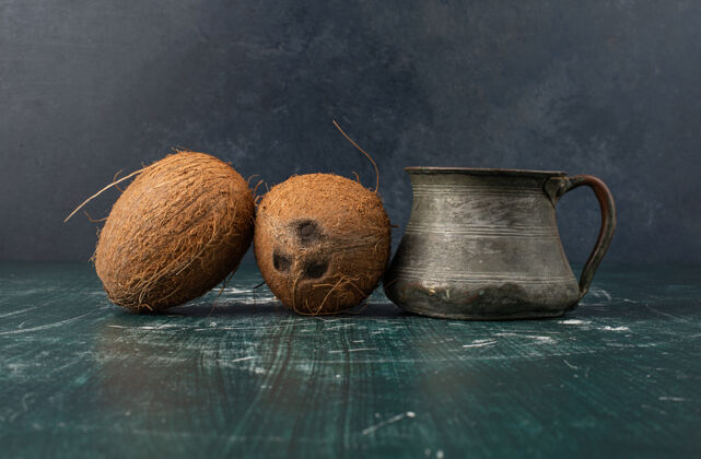 椰子两个完整的椰子和大理石桌上的经典花瓶椰子异国情调经典