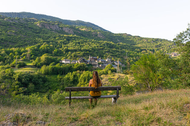 脸一个女人坐在长椅上面对山景的美丽镜头公园长凳山