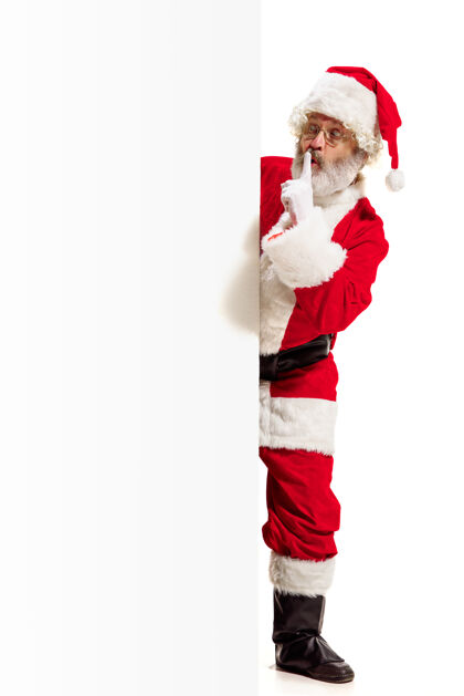 微笑惊喜的圣诞老人指着空白的广告墙上空白事件诺埃尔