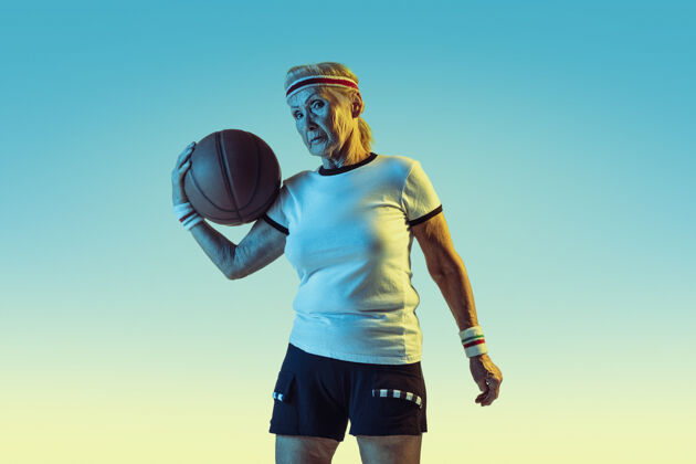 球拍穿运动服的老妇人在斜坡墙上打篮球乐趣老年人健康