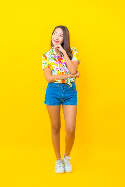 传统美丽的亚洲年轻女子穿着彩色衬衫在黄色墙上的肖像女孩多彩亚洲
