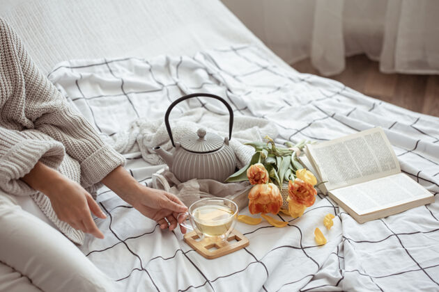 茶在床上放一杯茶 一个茶壶 一束郁金香和一本书房子作文床
