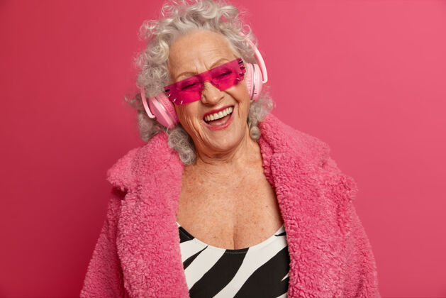 快乐穿着粉色紧身衣和外套 满脸皱纹的时尚老奶奶的特写照片女人大笑老
