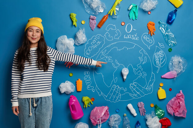 世界快乐亚洲女志愿者准备如何拯救地球免受污染的项目 展示塑料垃圾环绕的地球环境年轻人女人