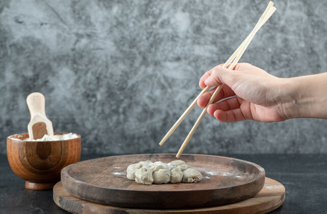 烹饪手拿筷子和饺子举行筷子蒸