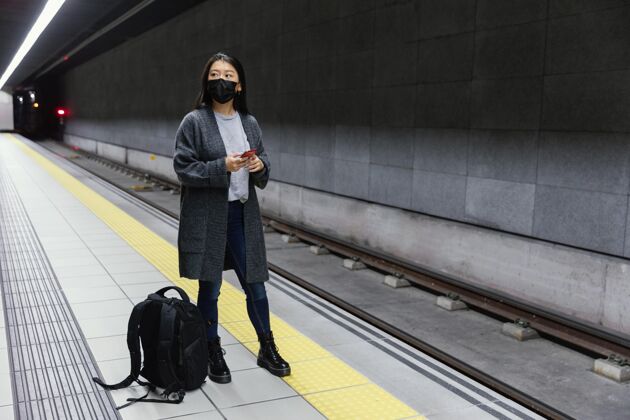 女人地铁站戴着面具的年轻女子年轻休闲模特