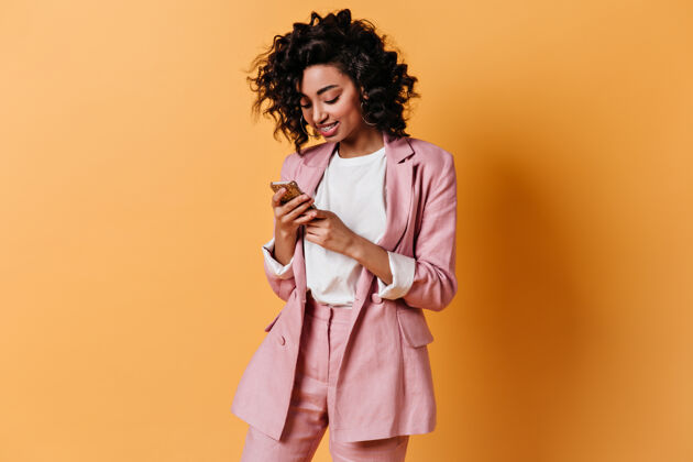 手机穿着粉色夹克微笑的女人在发短信女人手机数码设备
