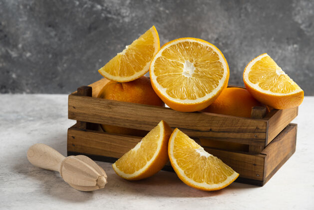 生的用木铰刀在大理石上切鲜橙子酸维生素天然