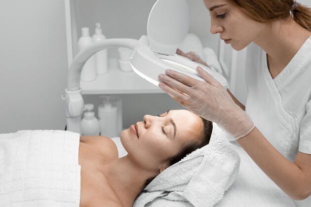 美容护理美容师为女性客户做美容常规沙龙面部护理女人