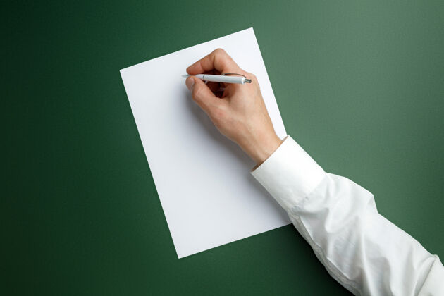 卡片男性手持笔 在绿色墙壁上的空白纸上书写文字或设计空白模板用于联系 广告或商业 金融 办公 采购复制空间小通信握住
