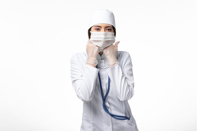 正面正面图女医生穿着白色医疗服 戴着口罩 因白墙上大流行疾病 健康医学可维医生男性疾病