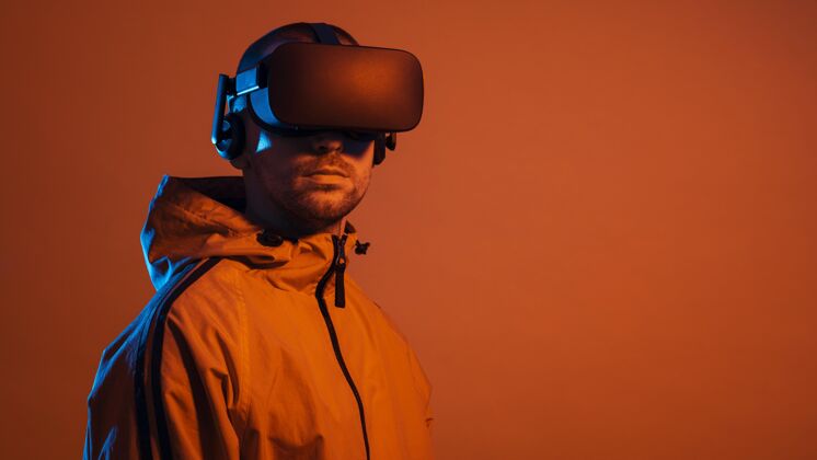 虚拟现实戴着虚拟现实装置的男人？带着橙色的光复制空间虚拟眼镜创新