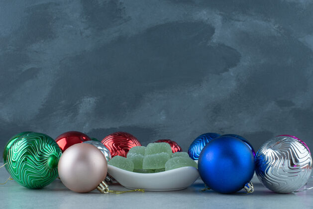 糖果圣诞喜庆球与白色盘子充满绿色果酱高品质的照片美味绿色果酱