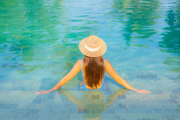 游泳肖像美丽的亚洲年轻女子放松微笑享受休闲围绕游泳池近海边度假海景乐趣游泳池水疗