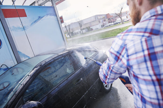 户外自助洗车的人擦洗洗发水飞溅