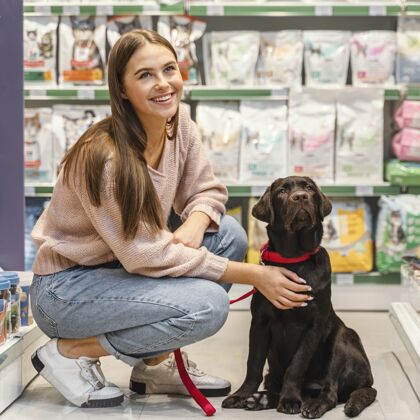 客户可爱的狗和女主人在宠物店商店消费动物