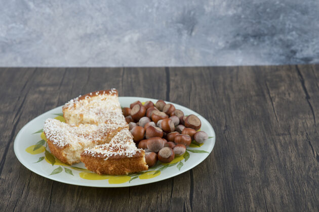 烹饪一块美味的蛋糕和澳洲坚果放在木桌上健康饼干派