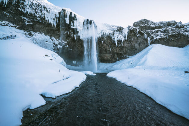 河流瀑布在雪间流下寒冷山脉冰