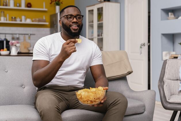男人男人看电视吃薯片薯条零食室内
