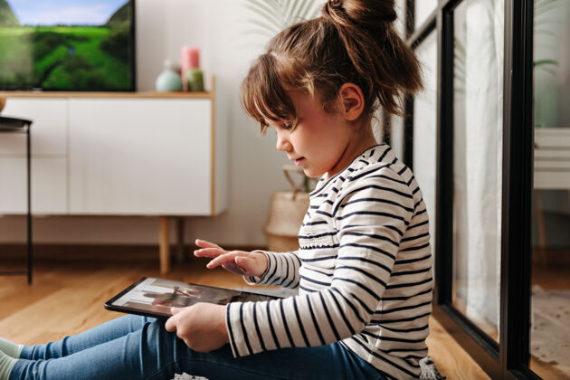 屏幕心情好的可爱小女人在平板电脑里看动画片 在客厅里摆姿势现代孩子Pc