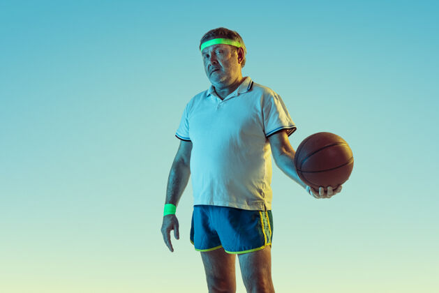 篮球高级男子在霓虹灯下的梯度背景下打篮球身材魁梧的白种人男模保持活跃 运动精神健康男性发球