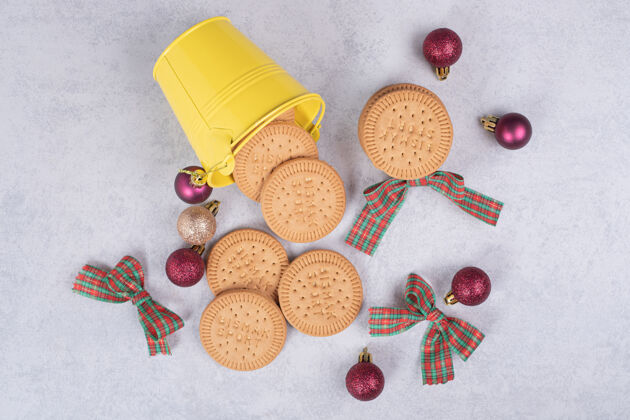 节日饼干桶装饰丝带和圣诞球在白色的桌子上高品质的照片饼干舞会糕点