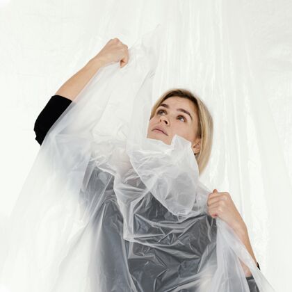 女人用塑料箔摆姿势的肖像女人模特工作室肖像