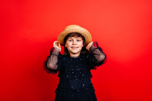 照片戴草帽的微笑的孩子穿着黑色连衣裙的微笑的小女孩肖像欢乐连衣裙