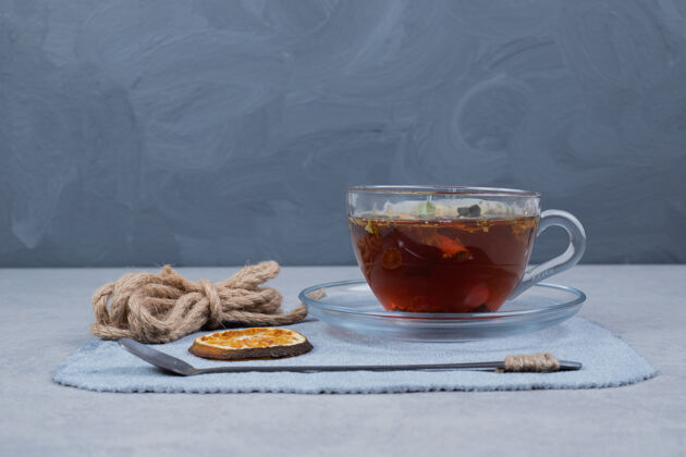 杯子在大理石桌上放一杯茶 一条绳和一片桂皮高质量的照片圣诞节勺子节日