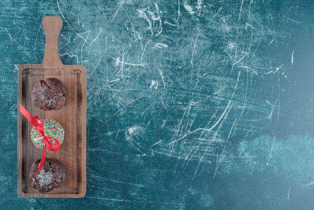 牙刷巧克力纸杯蛋糕和糖果包棒棒糖在蓝色背景板上高质量的照片糖果烘焙巧克力