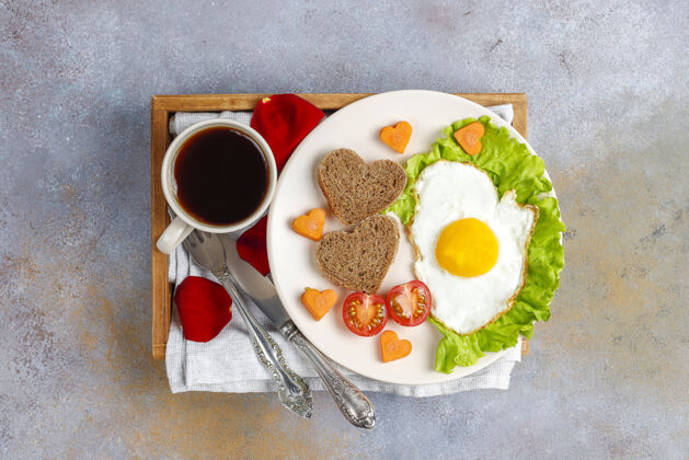 烹饪情人节早餐-炸鸡蛋 心形面包和新鲜蔬菜面包美食情人节
