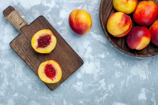 浅白色顶视图新鲜桃子醇厚可口的水果内棕色盘子在浅白色的办公桌上内部健康农产品