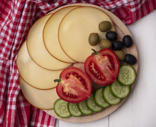 毛巾顶视图烟熏奶酪与西红柿黄瓜和橄榄上的立场与红色方格毛巾上的白色背景白的橄榄黄瓜
