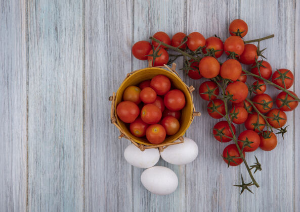 灰色桶上成熟番茄的俯视图 葡萄藤番茄和鸡蛋被隔离在灰色木质背景上 有复制空间复制膳食顶部
