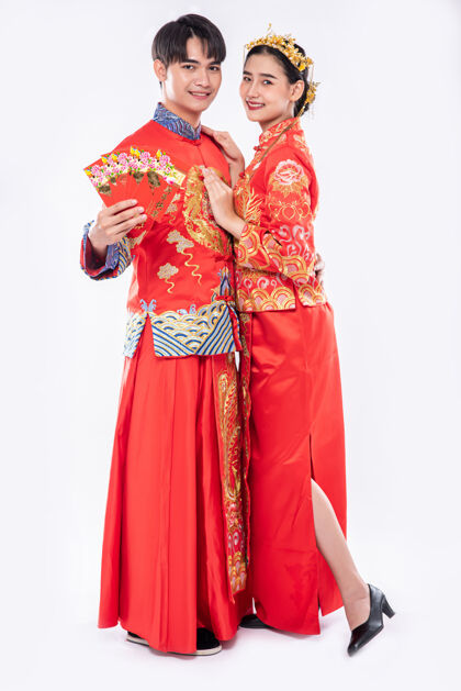 庆祝穿旗袍的男女在传统节日里展示他们的礼金和现金欢呼团体女性