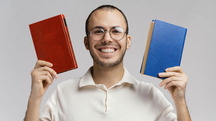 快乐一个拿着两本书大笑的男人模特书抱