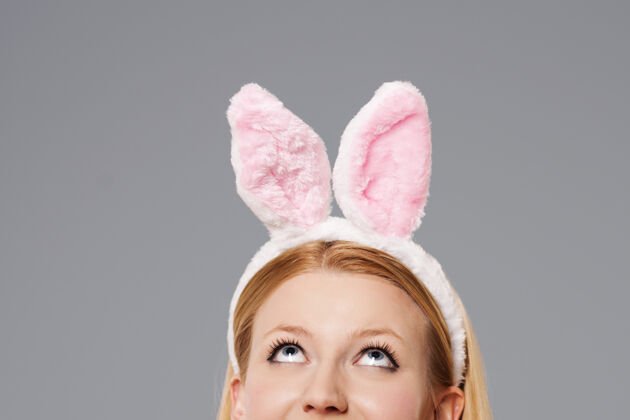 成人复活节兔女郎抬头看好奇窥视兔子