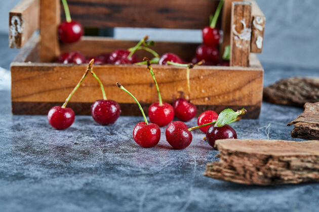 自然红红的新鲜多汁的樱桃放在一个有叶子的木箱里篮子成熟新鲜